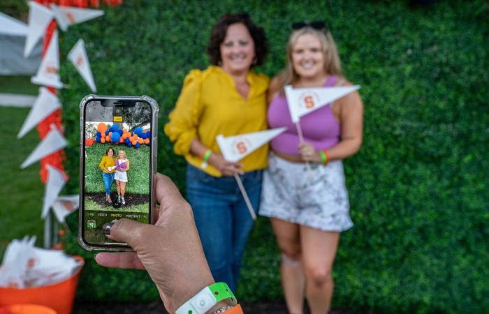 Two women posing for a photobooth picture at an event